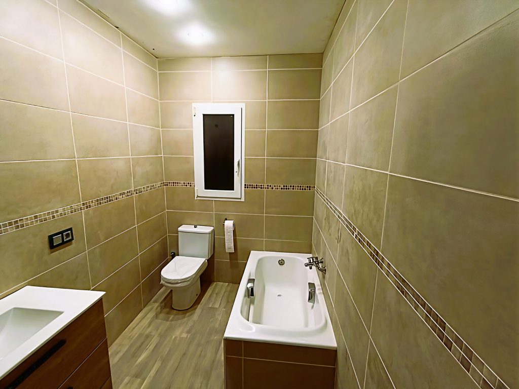 Baño con mueble de lavabo y revestimiento de pared