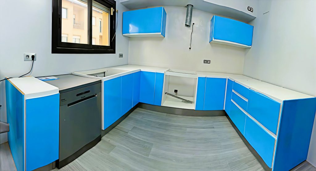Cocina con muebles azules y encimera clara
