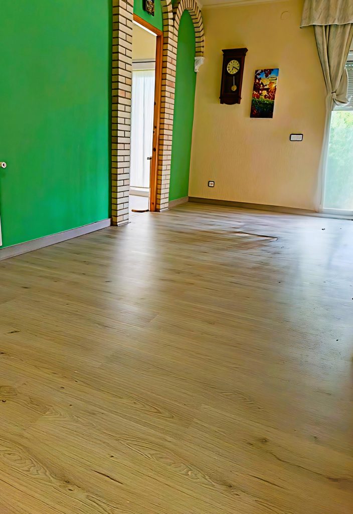 Suelo de parquet en una estancia con paredes verdes